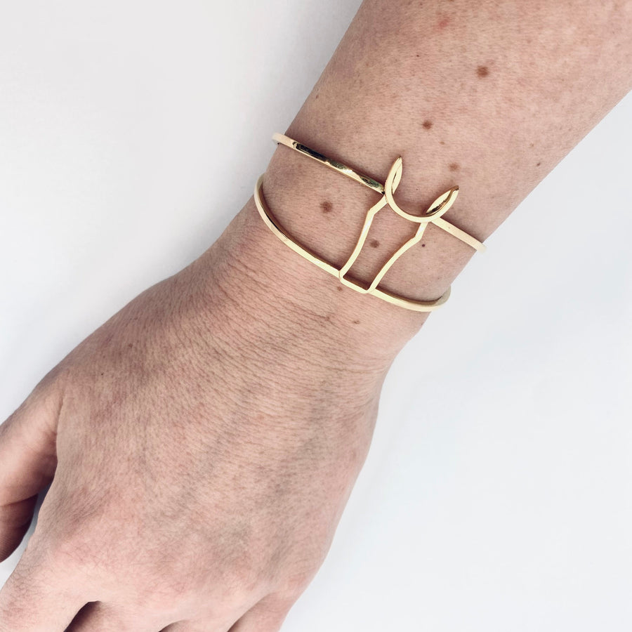 Gold horse bangle in context worn on arm. 
