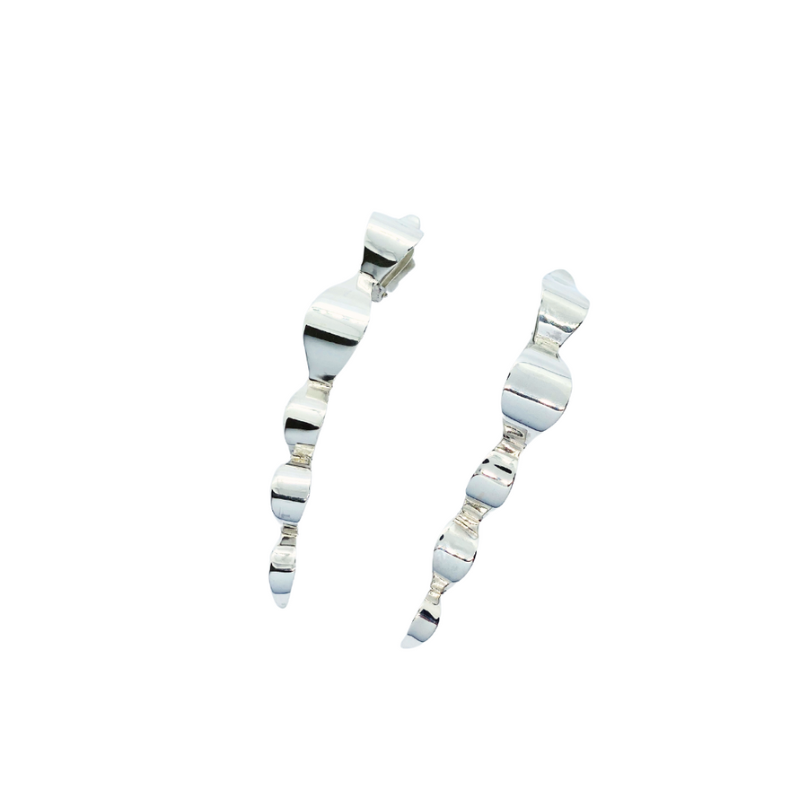 Wave earrings with clipons that ensure balanced weight. With sculpuratl silhouette that is contoured around the face with undulating silver waves