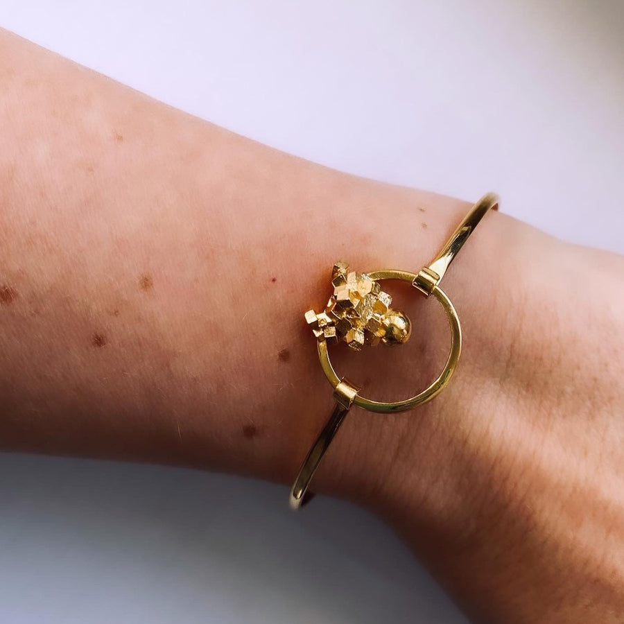 Gold cluster bracelet on wrist