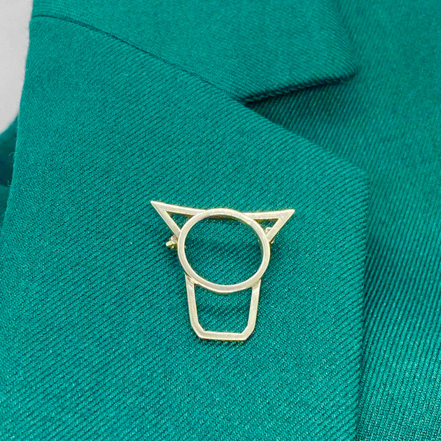 statement cow brooch in sterling silver on green lapel