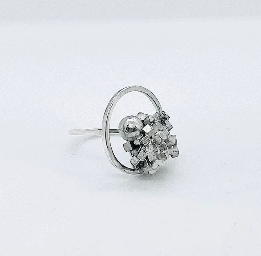 Demi cluster ring with sphere emanating from jumble of cubes in a sterling silver frame