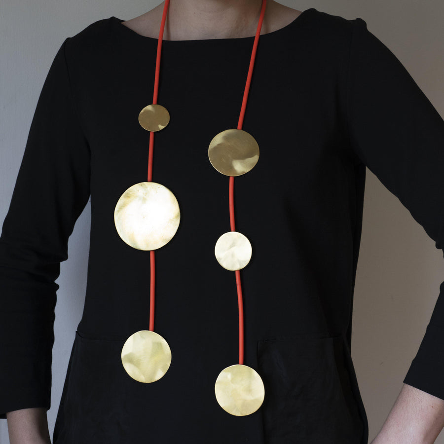 Hanging Moons Statement Pendant Necklace-Feeling very in tune with my femininity and closeness to nature, I really wanted to create a show stopper as a statement to convey this theme. This piece is a wonderfully arresting hanging necklace. It is surprisingly light to wear and looks fantastic against a black outfit for absolute visual impact. This piece is made from brass and silicone tubing but is available in silver or gold-plate on silver with a leather hanging cord. Get in touch to commission