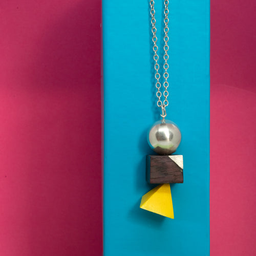 Geometric 3D Shapes Pendant-My love of geometric shapes and alternative materials comes alive in this 3D piece. The idea behind this pendant is that as people, sometimes we think of ourselves as one thing, then other times we may think the opposite, and then probably a bit of something else. We are human, fallible, emotional beings that evolve, take different shapes, adopt different attitudes and personalities. This piece uses a variety of materials: sterling silver, wood and plastic, each prese