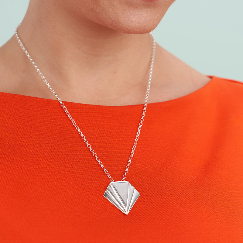 Coming Together Pendant-A contemporary twist on the art deco style, this bold statement pendant necklace will perfectly compliment any outfit. The pendant measures just under 3cm square (slightly longer than it is wide) anchored on a silver chain. This pendant necklace is a perfect choice when accessorising a symmetrical fashion style. Available in sterling silver, dipped gold, 9ct or 18ct gold. As the market price of gold varies, please DM for today’s price with no obligation to purchase.-Vanes